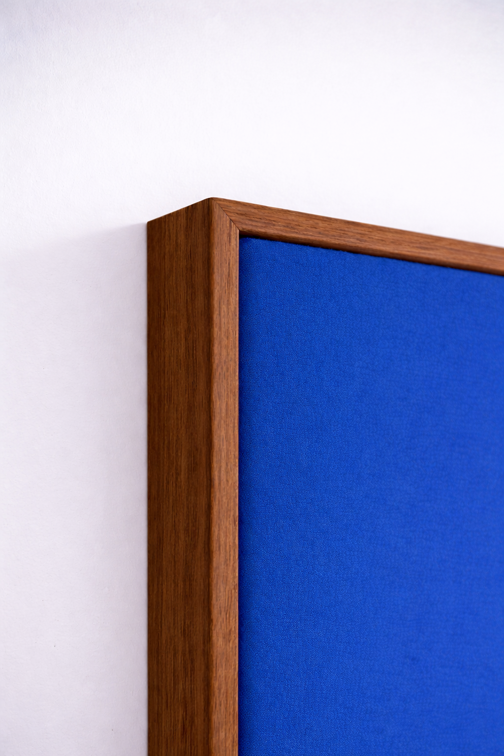 Gros plan sur un panneau acoustique Studio Zitto : finition bois massif et tissu tendu